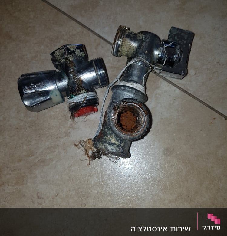 שני ברזים ישנים וחלודים על רצפה